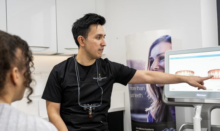 Dentist discussing scans of a patients teeth with the patient
