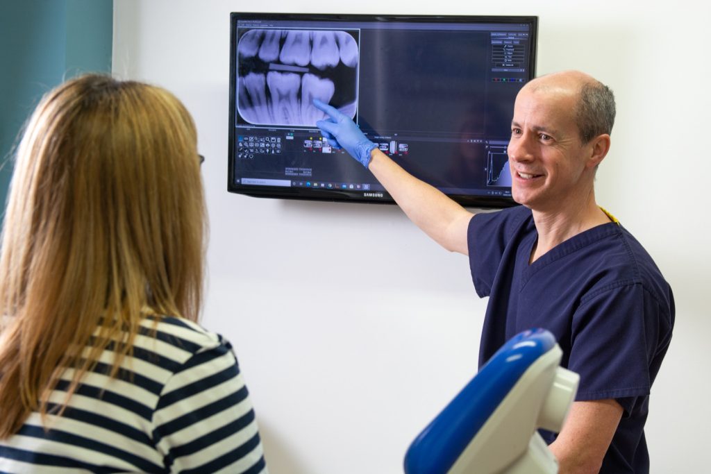 Dentist showing a patient an x-ray of their teeth